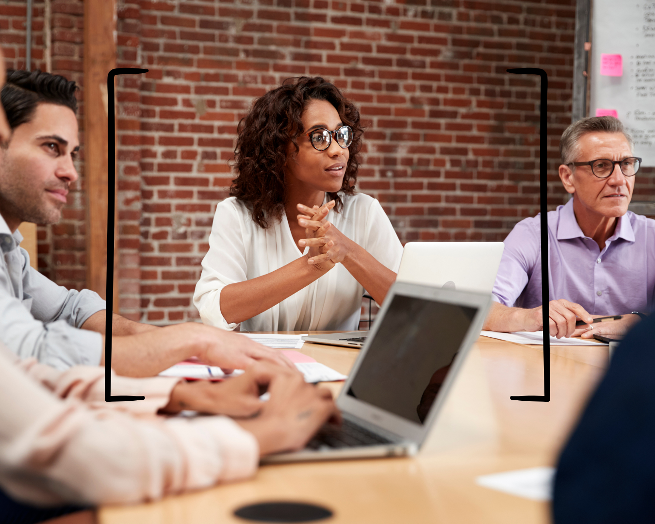 A new manager sitting at a conference table leading a team meeting, representing the concept of defining your leadership style before leading your first team